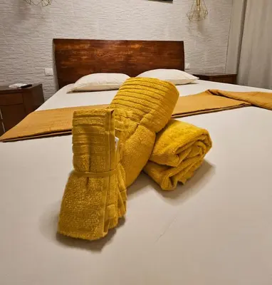 a bed with a pile of yellow blankets on it at Apartamentos Esperança in Sal Rei