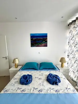 a bedroom with a bed with blue pillows on it at Casa BB&Djassi - Apartment T2 in Ponta do Sol