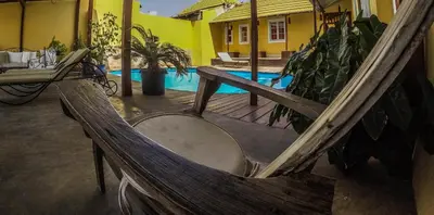 a wooden hammock sitting in front of a pool at The Colonial Guest House in São Filipe
