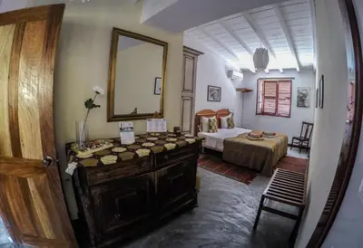 a bedroom with a bed and a dresser and a mirror at The Colonial Guest House in São Filipe