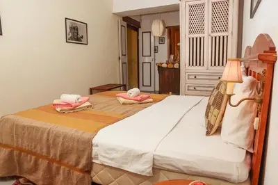 a bedroom with a bed with towels on it at The Colonial Guest House in São Filipe