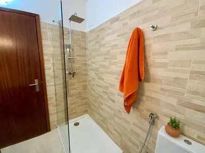 a bathroom with an orange towel hanging on a wall at Joia Escondida in Santa Maria