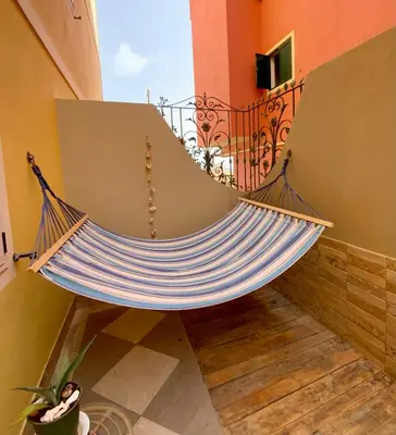 a hammock in a room with a balcony at Joia Escondida in Santa Maria