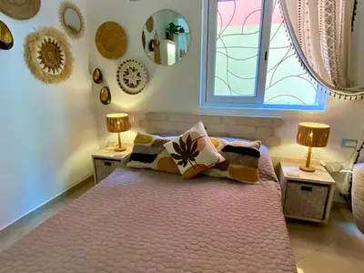 a bedroom with a bed with two lamps and a window at Joia Escondida in Santa Maria