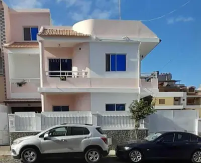 two cars parked in front of a house at Apart SilvaGomes in Praia