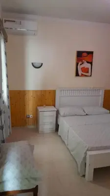 a bedroom with two beds and a dresser in it at Apart SilvaGomes in Praia