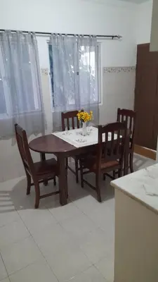 a dining room table and chairs with a table and flowers at Apart SilvaGomes in Praia