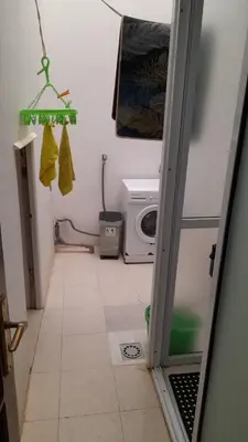 a bathroom with a washing machine and a microwave at Apart SilvaGomes in Praia