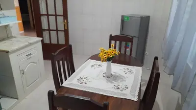a kitchen with a table with a vase of flowers on it at Apart SilvaGomes in Praia