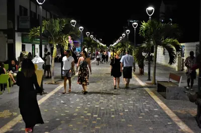 a group of people walking down a street at night at Cosy 2 Bed Apartment Vila Verde Santa Maria in Santa Maria