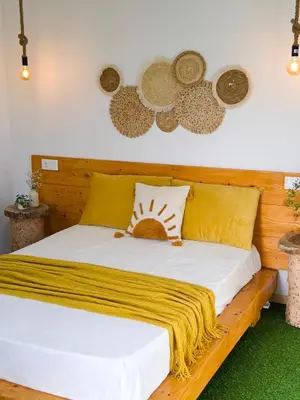 a wooden bed with yellow pillows and hats on the wall at Quinta Refúgio in Ribeirão Chiqueiro