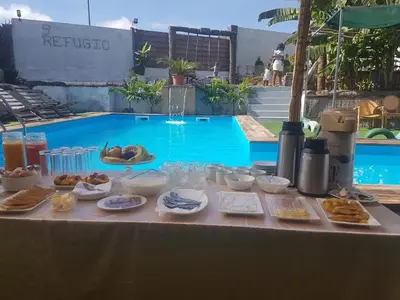 a table with food on it next to a swimming pool at Quinta Refúgio in Ribeirão Chiqueiro