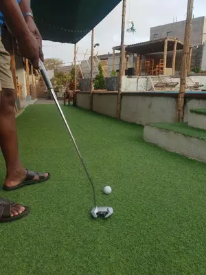 a man is hitting a golf ball with a club at Quinta Refúgio in Ribeirão Chiqueiro