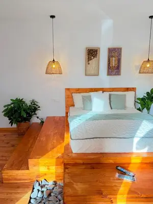 a bedroom with a large bed with a wooden floor at Quinta Refúgio in Ribeirão Chiqueiro