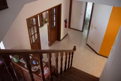 a staircase leading to a hallway with two doors at Simabo's Backpackers' Hostel in Mindelo