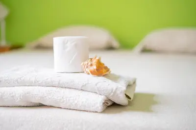 a pile of towels and a donut on a bed at Simabo's Backpackers' Hostel in Mindelo