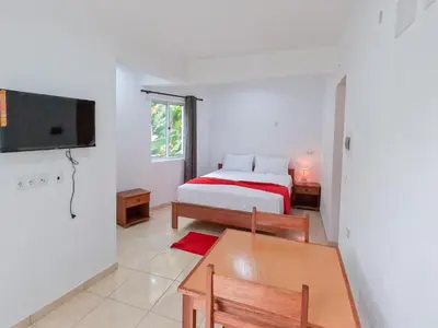 a bedroom with a bed and a table and a tv at Residencial Mãe Nona in Ribeira Grande