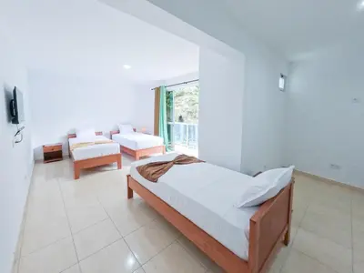 a bedroom with a bed and a couch and a window at Residencial Mãe Nona in Ribeira Grande