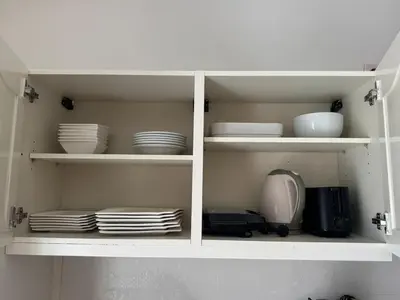 a white cabinet with plates and dishes in it at Murdeira V152 Duplex by RPG Group in Beirona