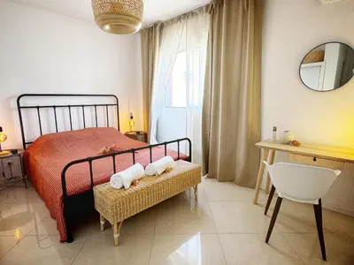 a bedroom with a bed and a table and a chair at Mindelo Bay Apartment in Mindelo