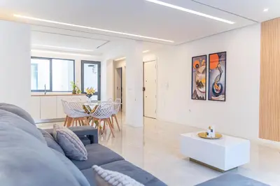 a living room with a blue couch and a table at 3-bdr apt 10-min walk laginha beach - LCGR in Mindelo