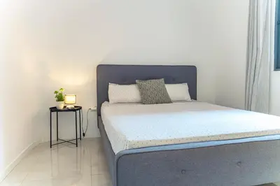a bed with a blue headboard in a bedroom at 3-bdr apt 10-min walk laginha beach - LCGR in Mindelo