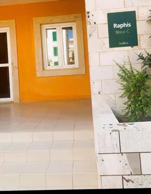 a building with a window and a sign on it at Raphis-Belux in Santa Maria