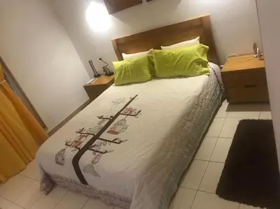 a bedroom with a bed with white sheets and green pillows at Raphis-Belux in Santa Maria