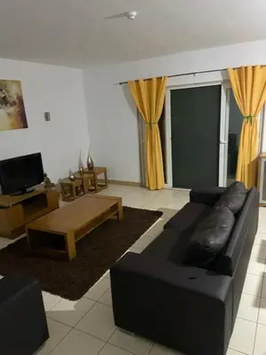 a living room with a black couch and a coffee table at Raphis-Belux in Santa Maria