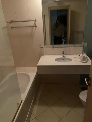 a man taking a picture of a bathroom with a tub and sink at Raphis-Belux in Santa Maria
