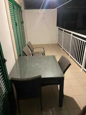 a table and chairs in a room with a balcony at Raphis-Belux in Santa Maria