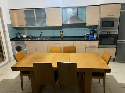 a kitchen with a wooden table and chairs at Raphis-Belux in Santa Maria