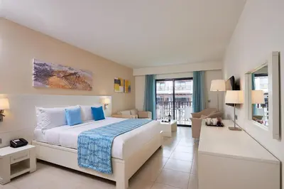 a bedroom with a bed and a living room at Meliá Laguna Beach in Santa Maria