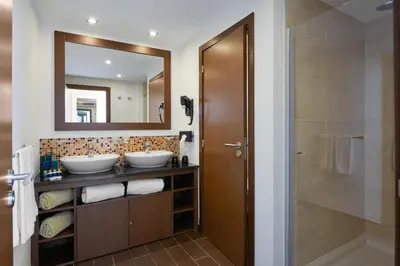 a bathroom with two sinks and a mirror at Meliá Laguna Beach in Santa Maria
