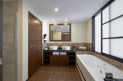 a bathroom with two sinks and a tub and a mirror at Meliá Laguna Beach in Santa Maria