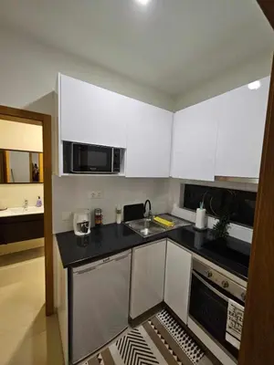 a kitchen with white cabinets and a sink at Sheila Apartment in Espargos