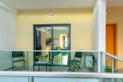 a balcony with two chairs and a table at 1 Bedroom - 150m from the Beach - Pool in Santa Maria
