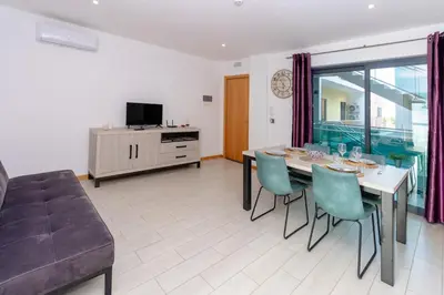 a living room with a table and chairs and a couch at 1 Bedroom - 150m from the Beach - Pool in Santa Maria
