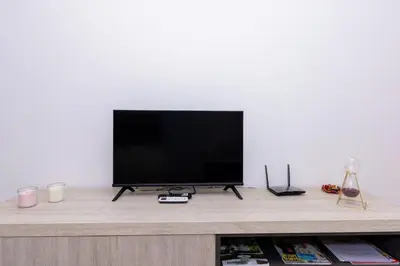 a flat screen tv sitting on top of a wooden entertainment center at 1 Bedroom - 150m from the Beach - Pool in Santa Maria