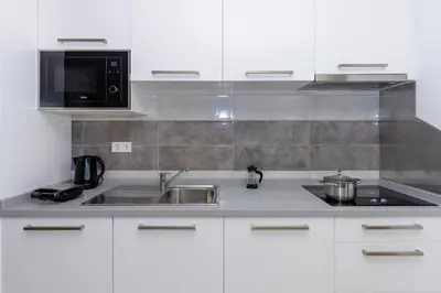 a kitchen with a sink and a microwave at 1 Bedroom - 150m from the Beach - Pool in Santa Maria