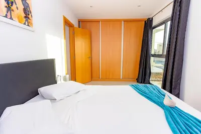 a bedroom with a bed with a window and a door at 1 Bedroom - 150m from the Beach - Pool in Santa Maria