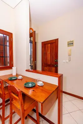 a dining room with a wooden table and chairs at T1 - 800m from the beach - located in the city center in Santa Maria