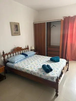 a bedroom with a bed with two blue pillows on it at MeloMar Rooms in Ponta do Sol