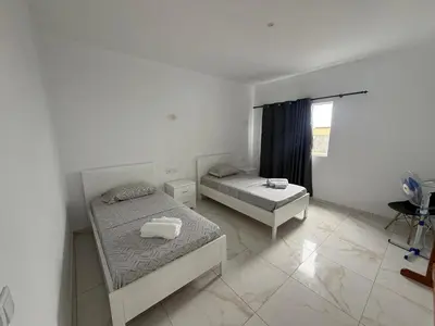 a bedroom with two beds and a window at MeloMar Rooms in Ponta do Sol
