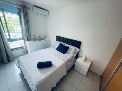 a bedroom with a bed with blue pillows on it at APPARTEMENT IDEAL POUR ESCALE a PRAIA in Praia
