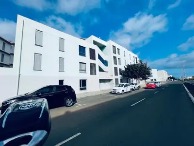 a white building with cars parked on the side of a street at Dormir à Praia Cap vert autour de l'aéroport in Praia