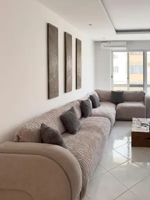 a living room with a large couch with pillows at 3 bdr cozy apt, Exterior POOL , Cidadela - LCGR in Praia