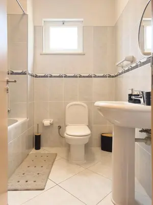 a white bathroom with a toilet and a sink at 3 bdr cozy apt, Exterior POOL , Cidadela - LCGR in Praia