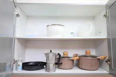 a shelf with pots and pans in a refrigerator at 1 bedroom apartment with sofa bed 4 min walk from the beach in Santa Maria