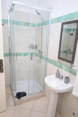a bathroom with a shower and a sink at 1 bedroom apartment with sofa bed 4 min walk from the beach in Santa Maria